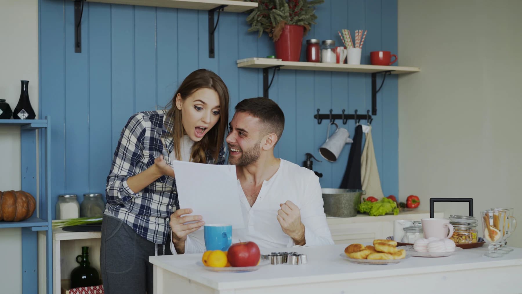 Un couple lit une lettre dans sa cuisine